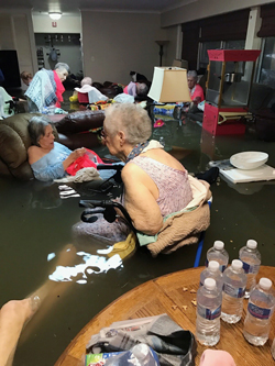 In this Sunday, Aug. 27, 2017, photo provided by Trudy Lampson, residents of the La Vita Bella nursing home in Dickinson, Texas, sit in waist-deep flood waters caused by Hurricane Harvey. (Trudy Lampson via AP)